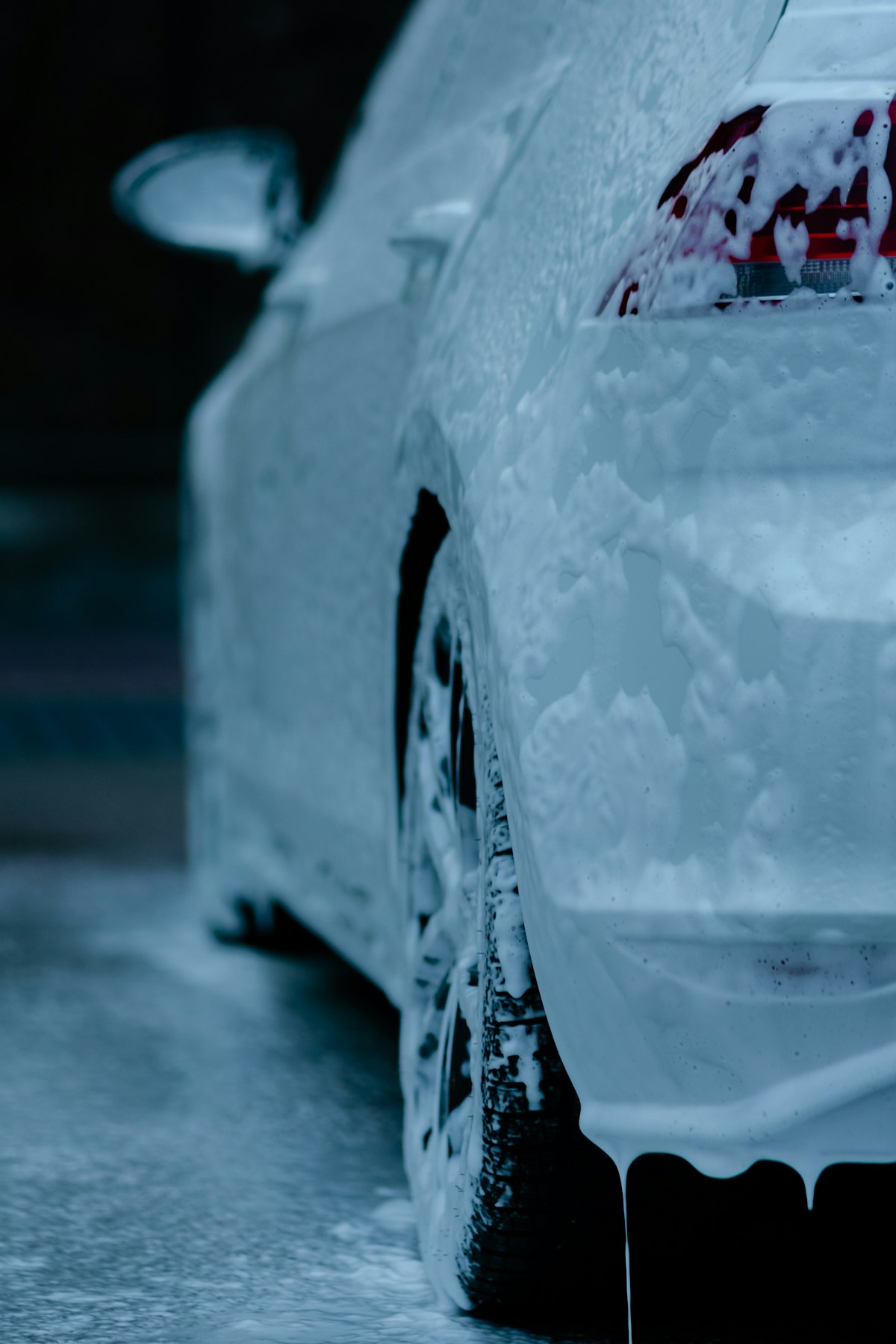 Soapy car being rinsed by hand
