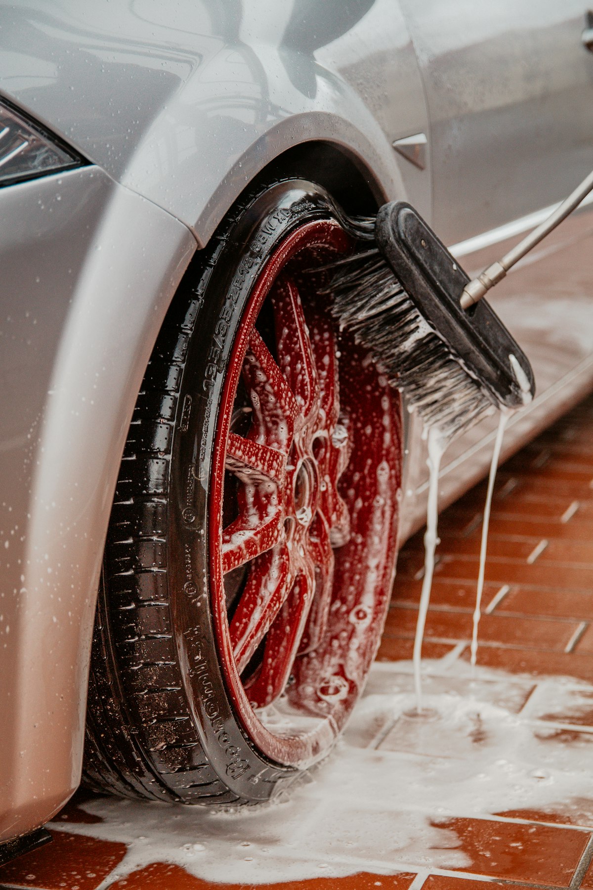 Wheel and tire being scrubbed by hand with a brush
